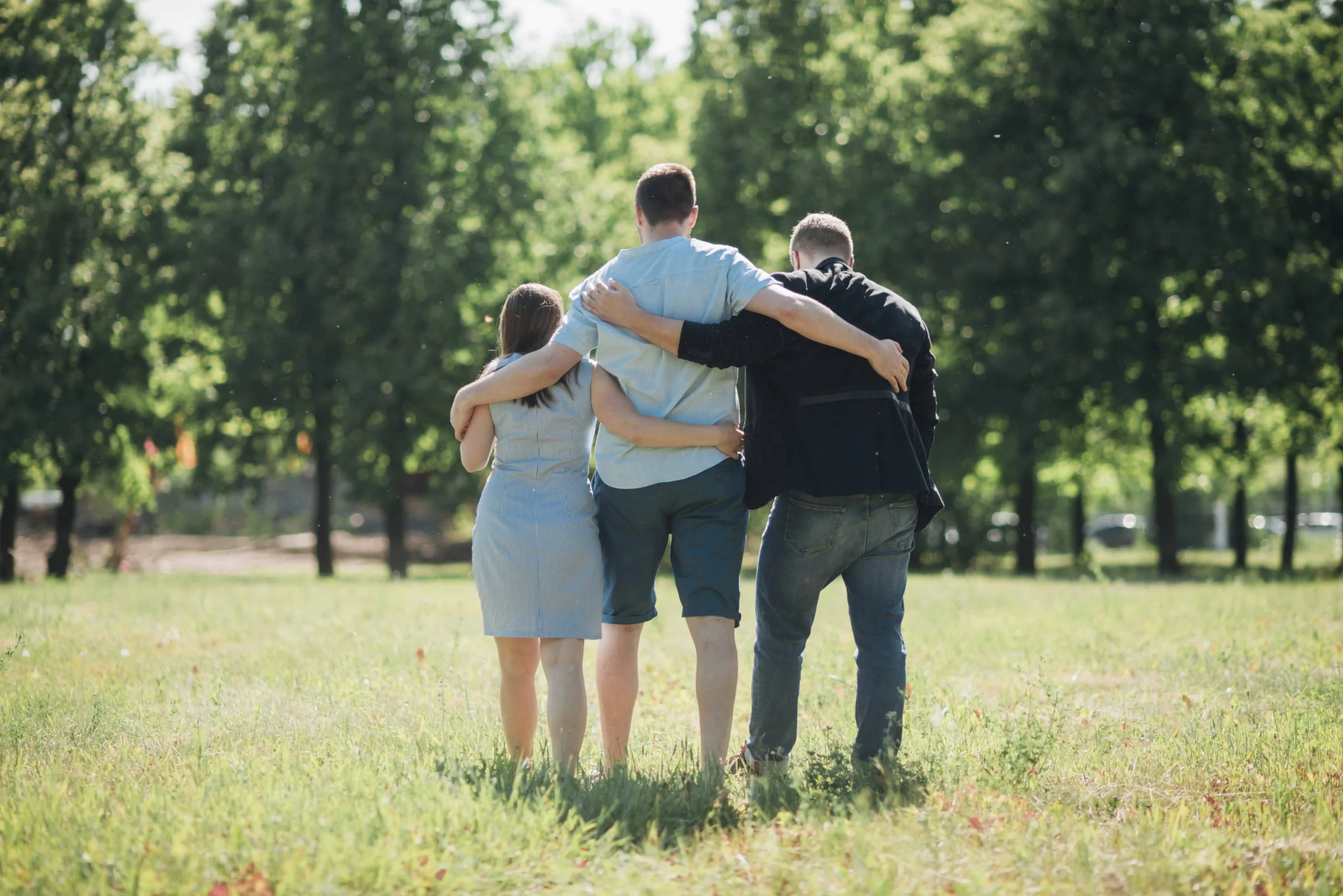 3 people in an enm relationship walking through a field