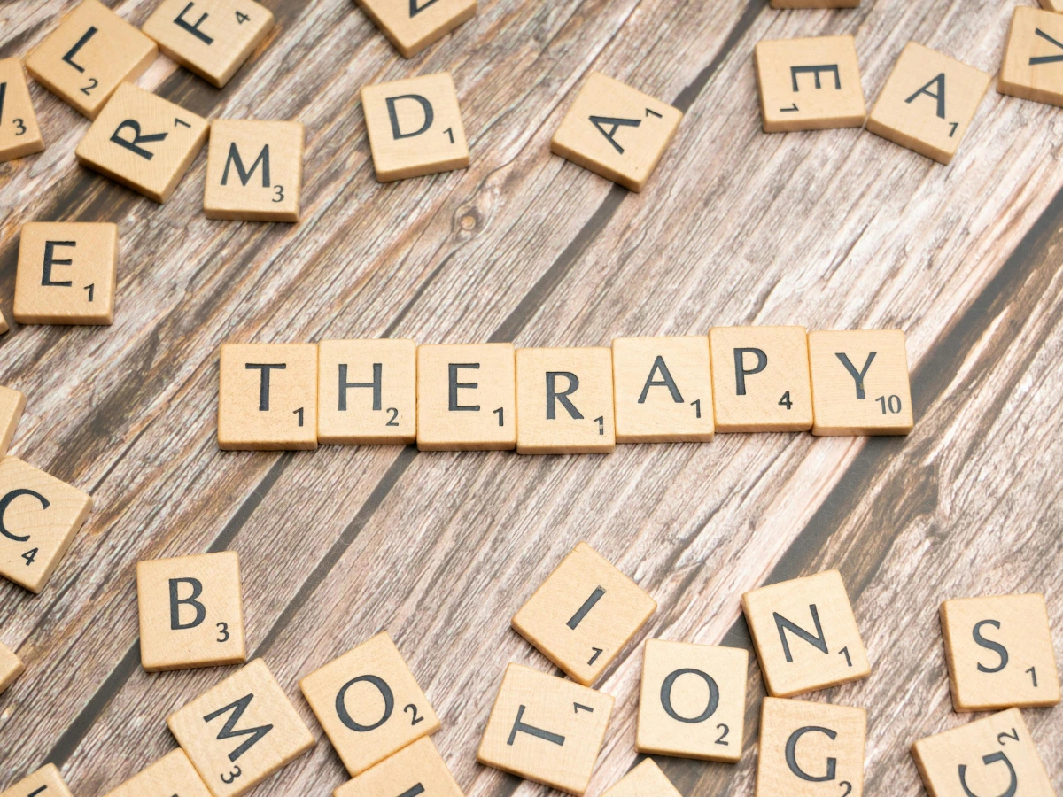 wooden letters used in scrabble spelled therapy